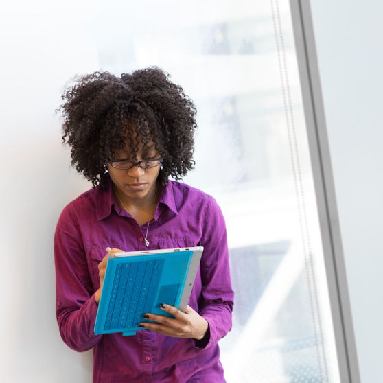 Woman in purple dress shirt using laptop